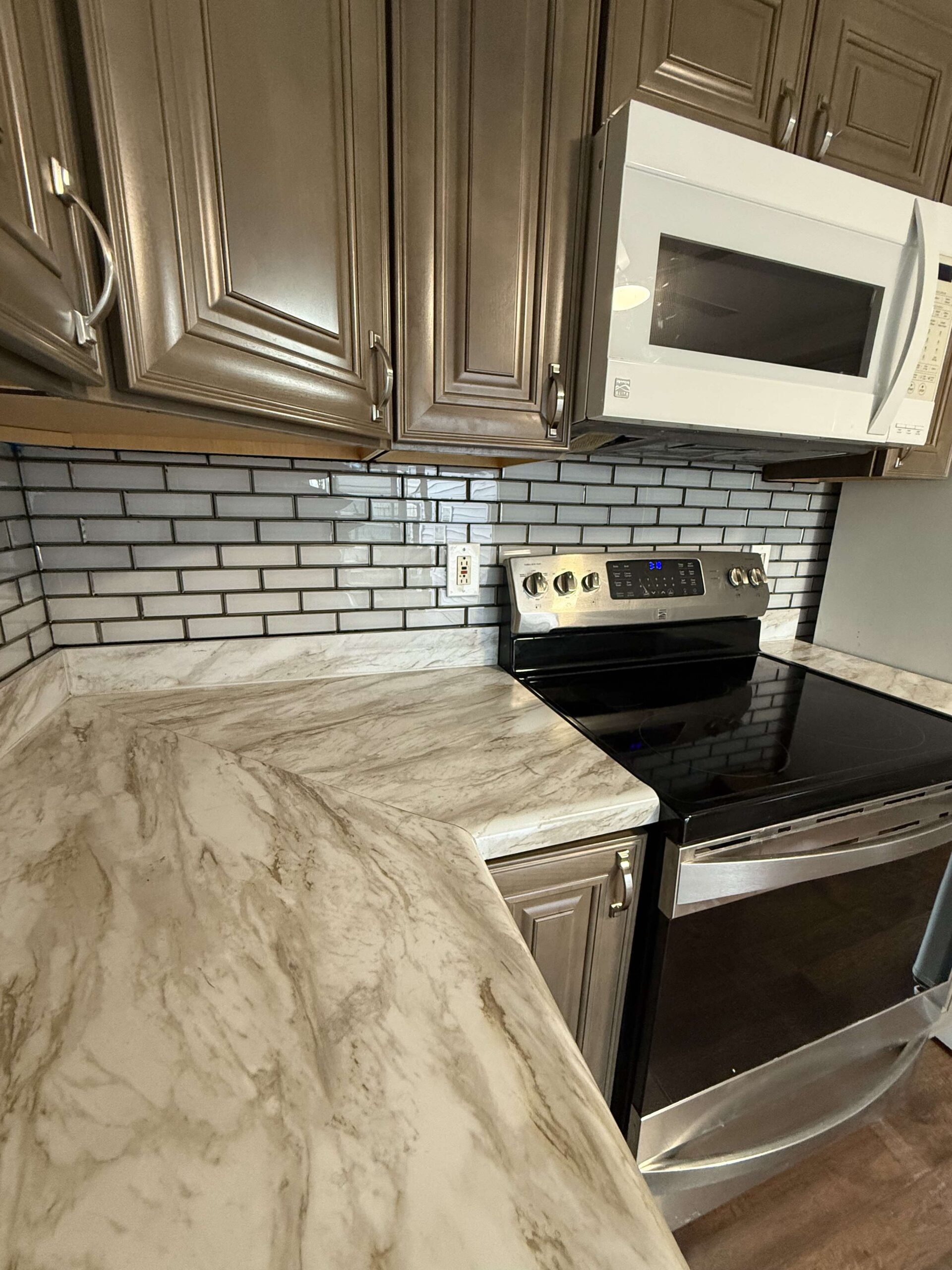 a kitchen with a marble counter top and a microwave